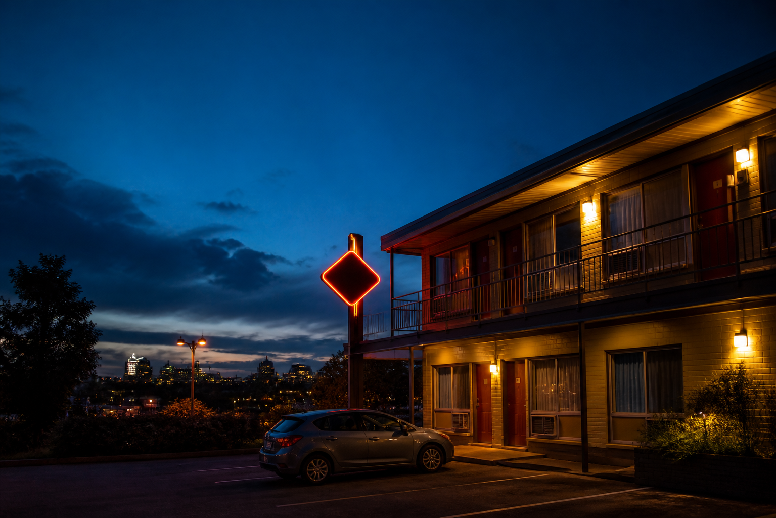 A welcoming motel exterior at dusk with Montreal in the distance